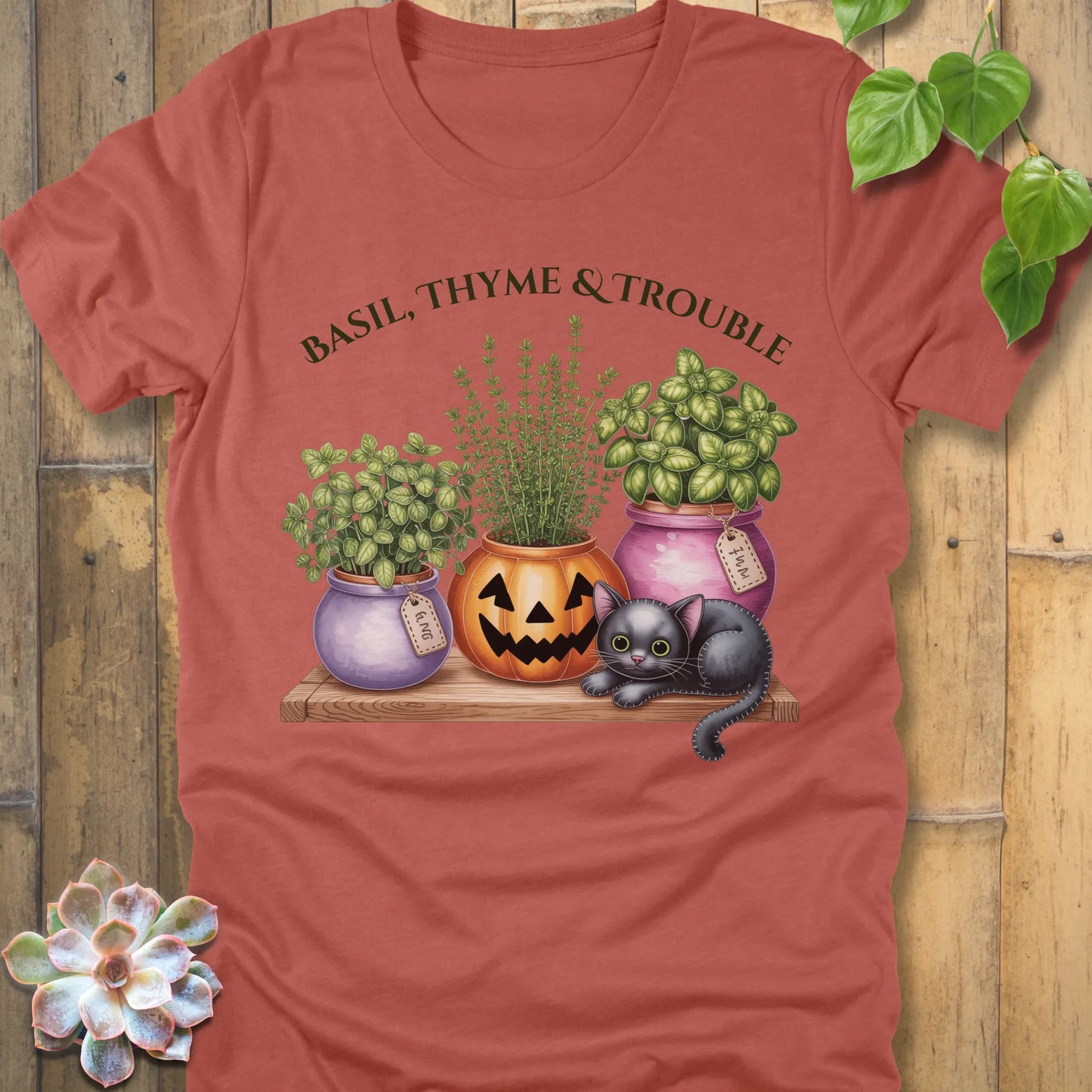 Heather Clay t-shirt featuring the design "Basil, Thyme & Trouble" printed in bold green letters and a plants, cats 