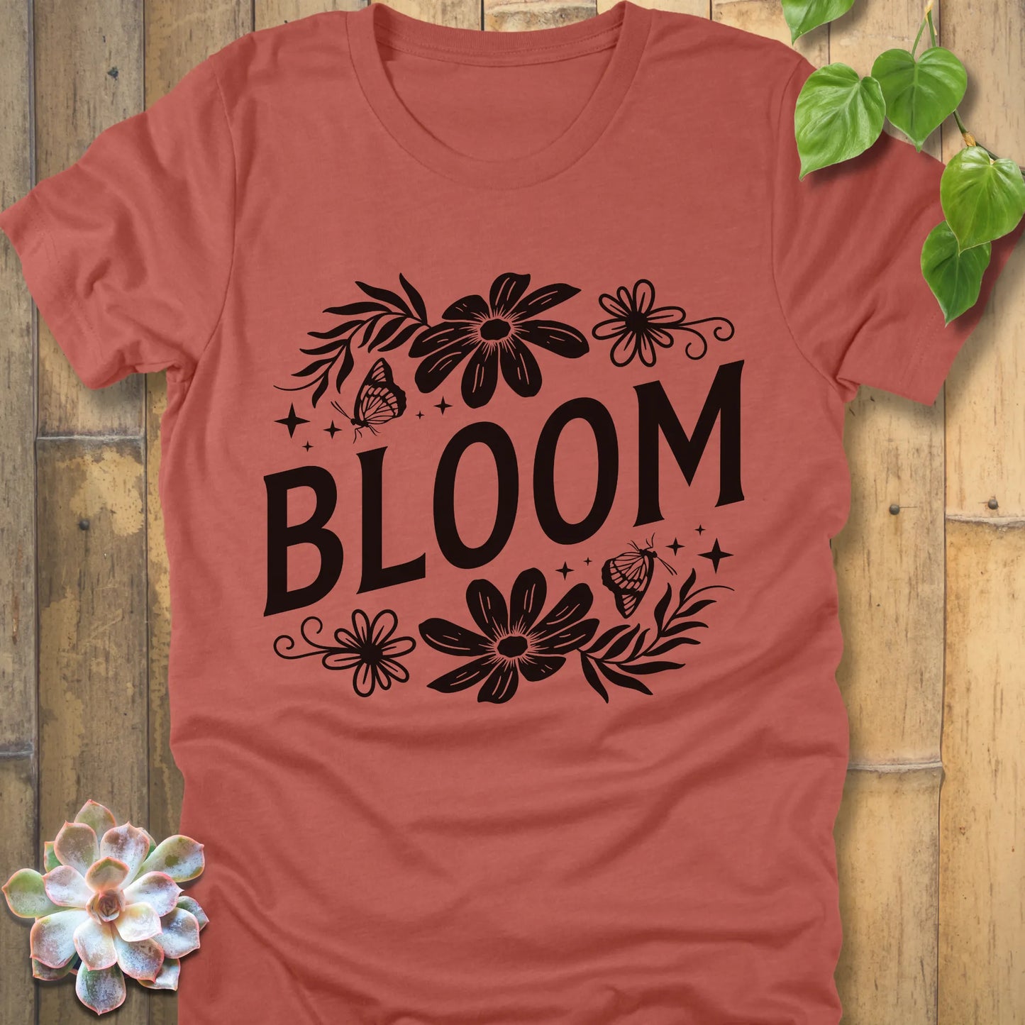 Heather Clay t-shirt featuring the design " Bloom " printed in bold black letters with flowers
