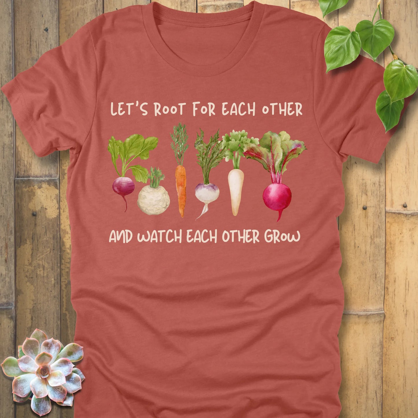 Heather Clay t-shirt featuring the design Let’s Root printed in bold letters and a vegetables, casual gardening shirt.