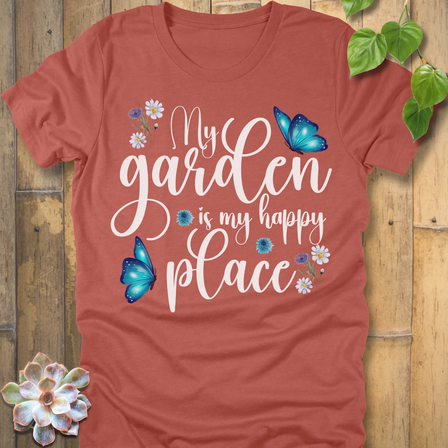 Heather Clay t-shirt featuring the design My Garden Is My Happy Place with blue butterfly and flowers, funny floral gardening shirt for women.