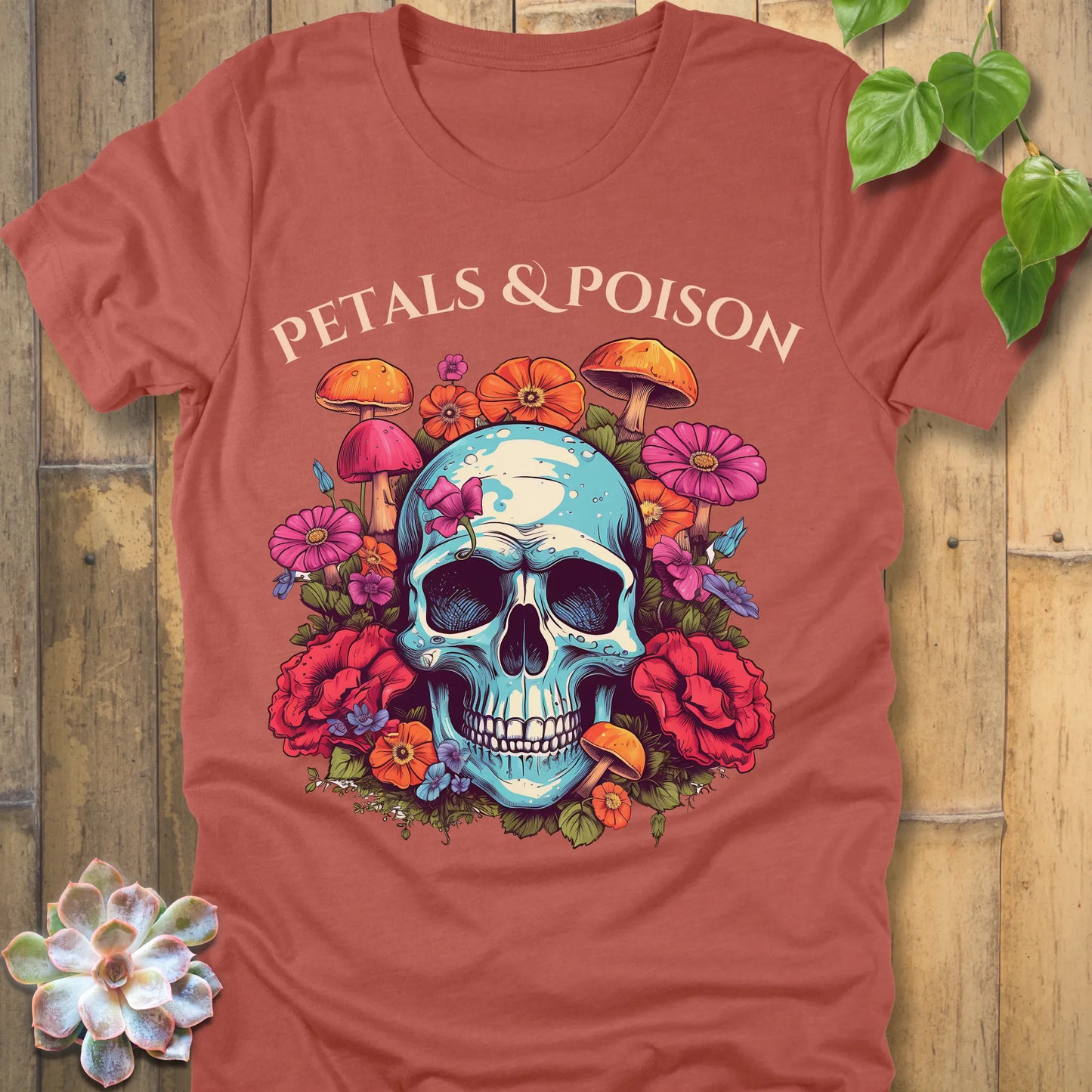 Heather Clay t-shirt featuring the design Petals & Poison printed in bold letters and a flowers, mushroom and skull