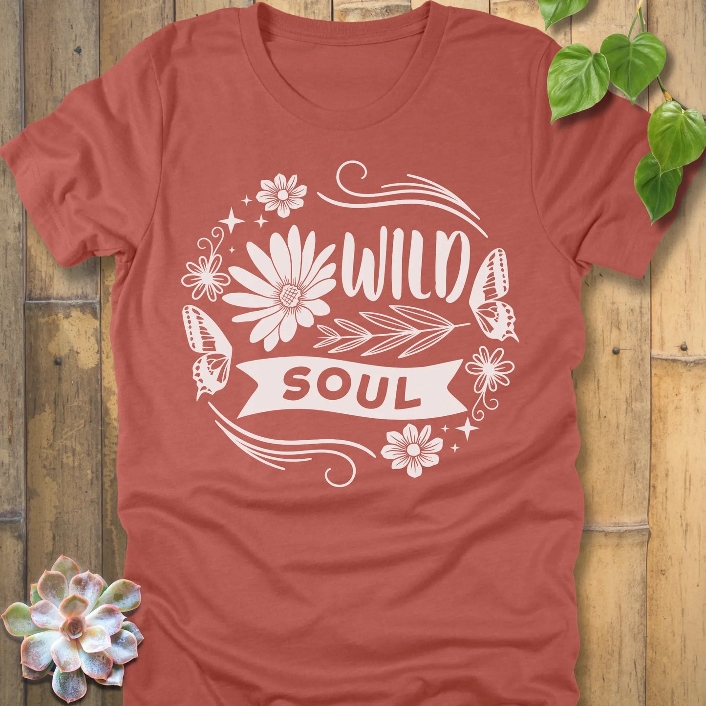 Heather Clay t-shirt featuring the design Wild Soul printed in bold letters and flower, butterfly