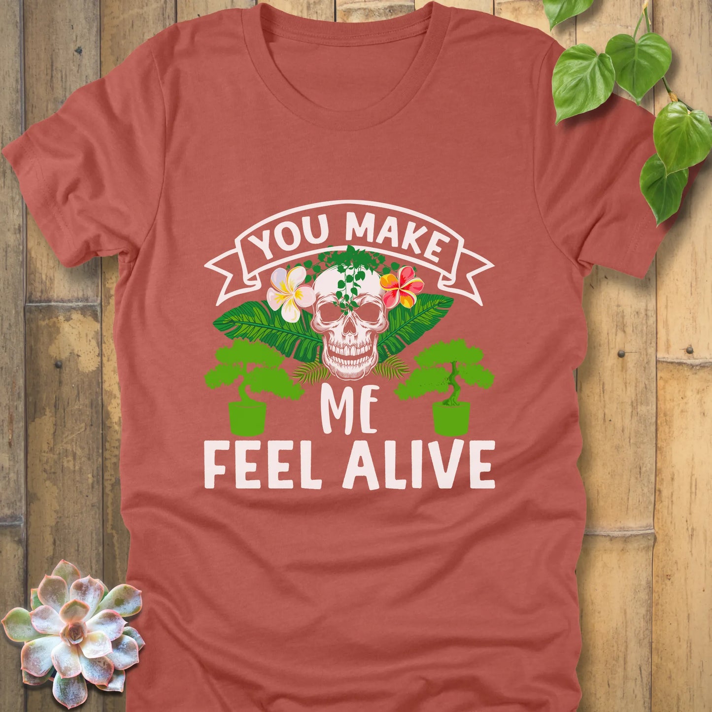 Heather Clay t-shirt featuring the design You Make Me Feel Alive printed in bold white letters with skull and plants