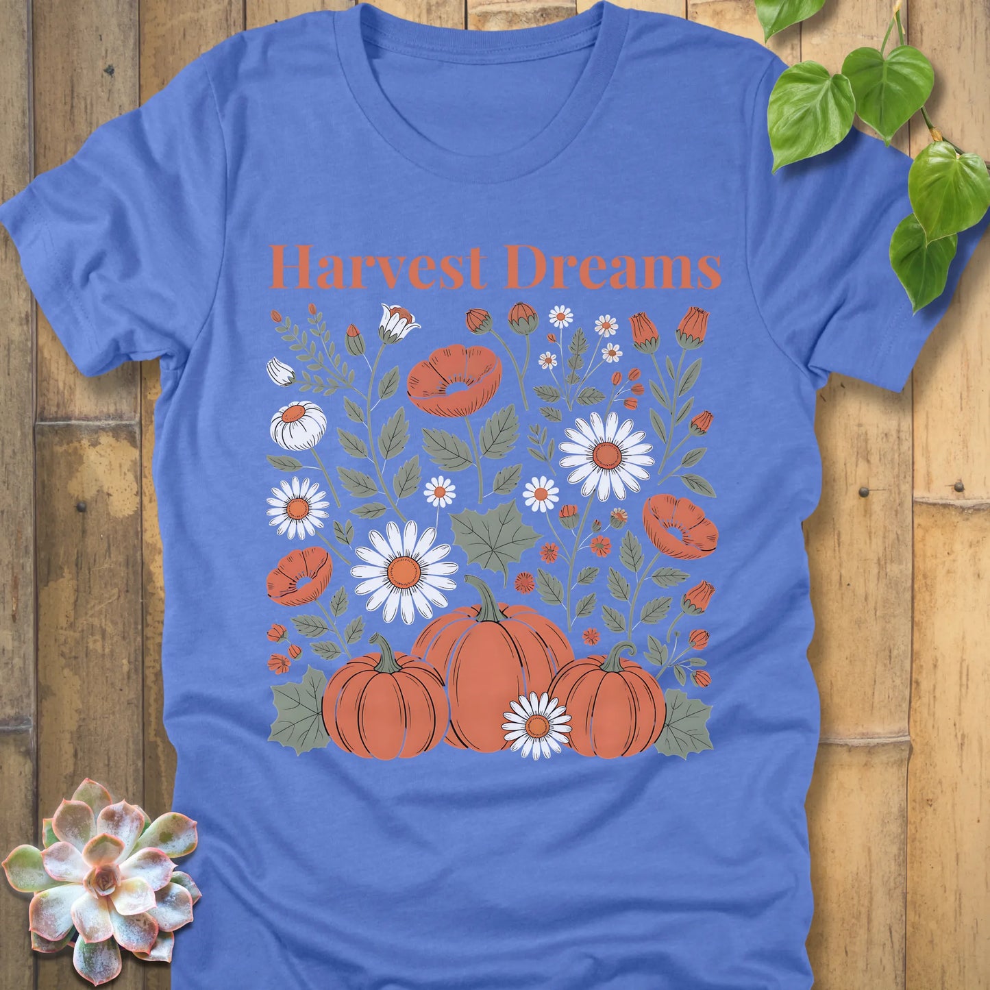 Heather Colombia Blue t-shirt featuring the design Harvest Dreams printed in orange letters flowers and pumpkin
