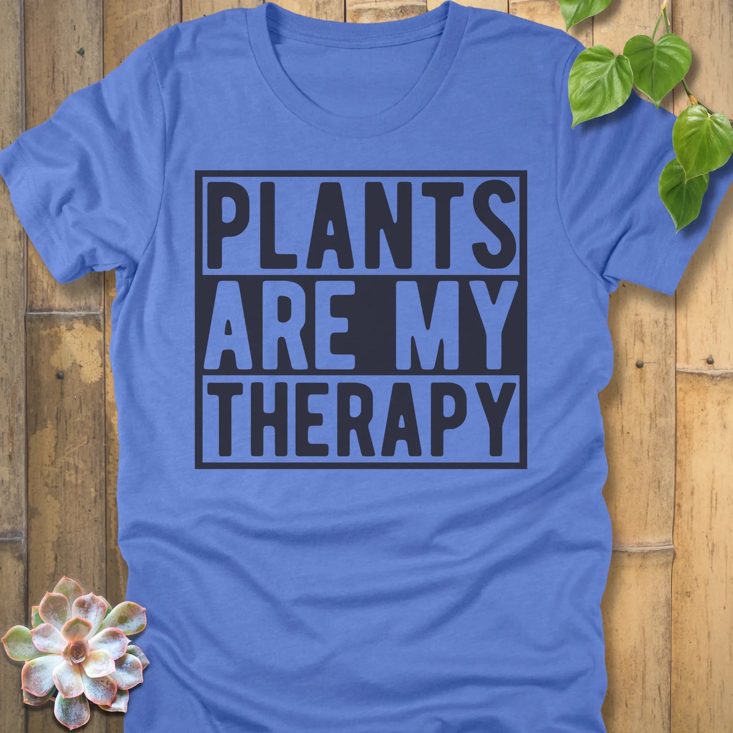 Heather Columbia Blue t-shirt featuring the design Plants Are My Therapy printed in bold letters, plant lover shirt.