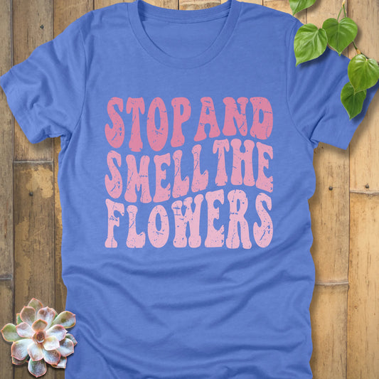 Heather Columbia Blue t-shirt featuring the design Smell The Flowers printed in bold letters, casual gardening shirt.