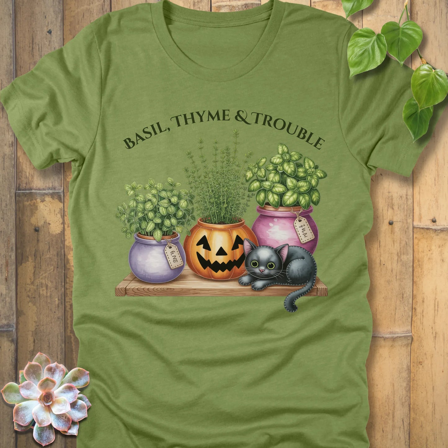 Heather Green t-shirt featuring the design "Basil, Thyme & Trouble" printed in bold green letters and a plants, cats 