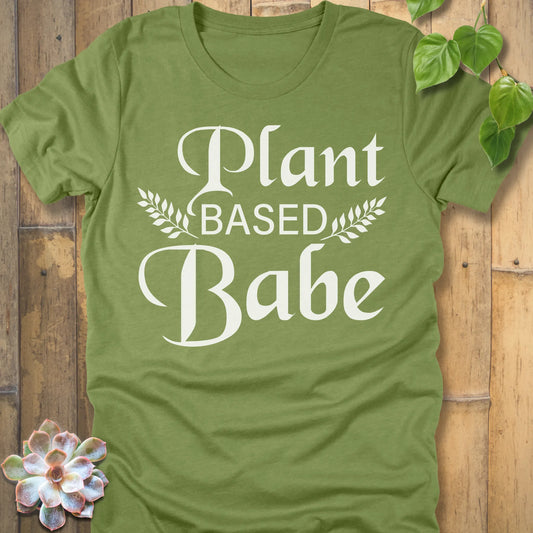 Heather Green t-shirt featuring the design Plant Based Babe printed in bold letters and a graphic leaves, vegan lifestyle shirt.