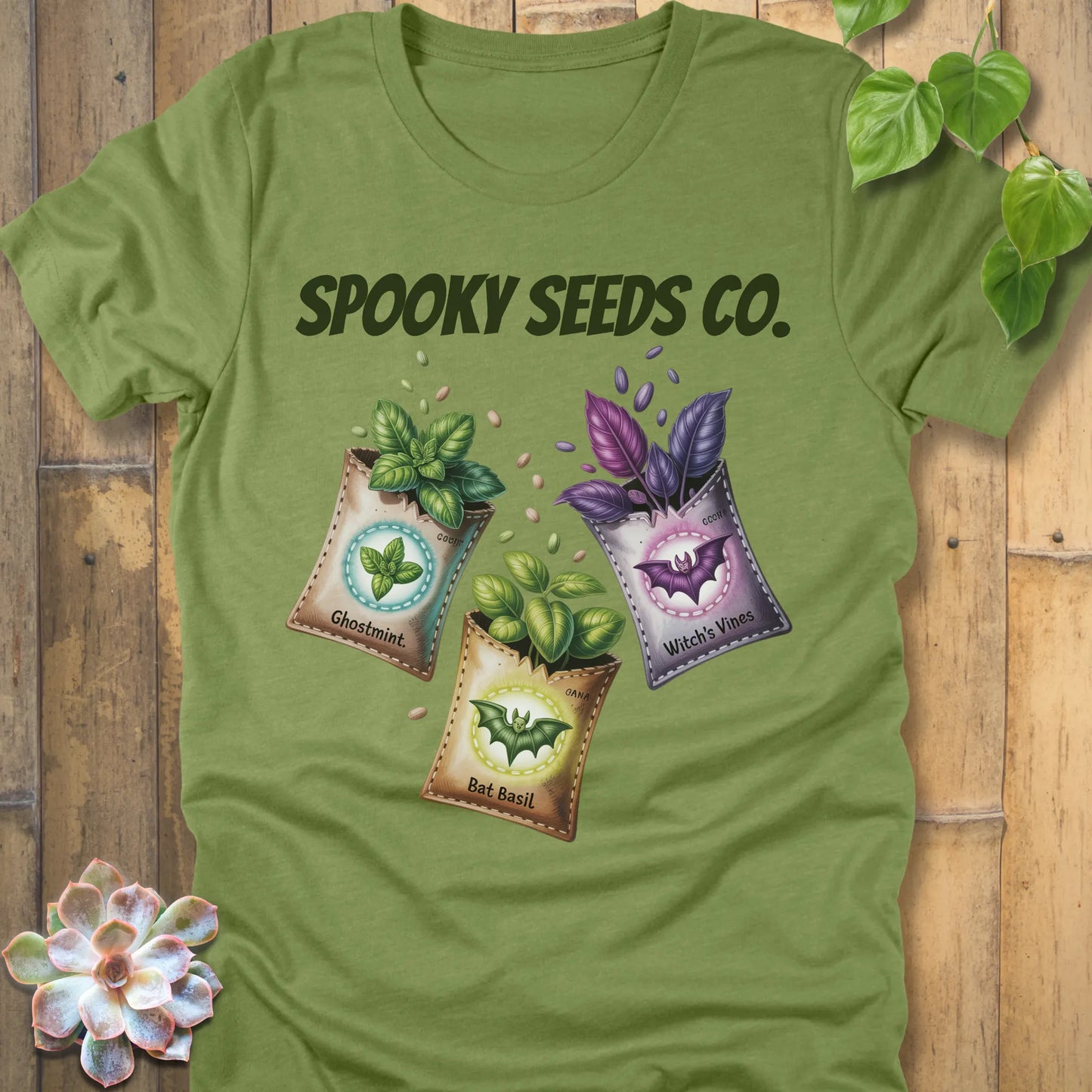 Heather Green t-shirt featuring the design Spooky Seeds Co. printed in bold letters  and a halloween design and plants