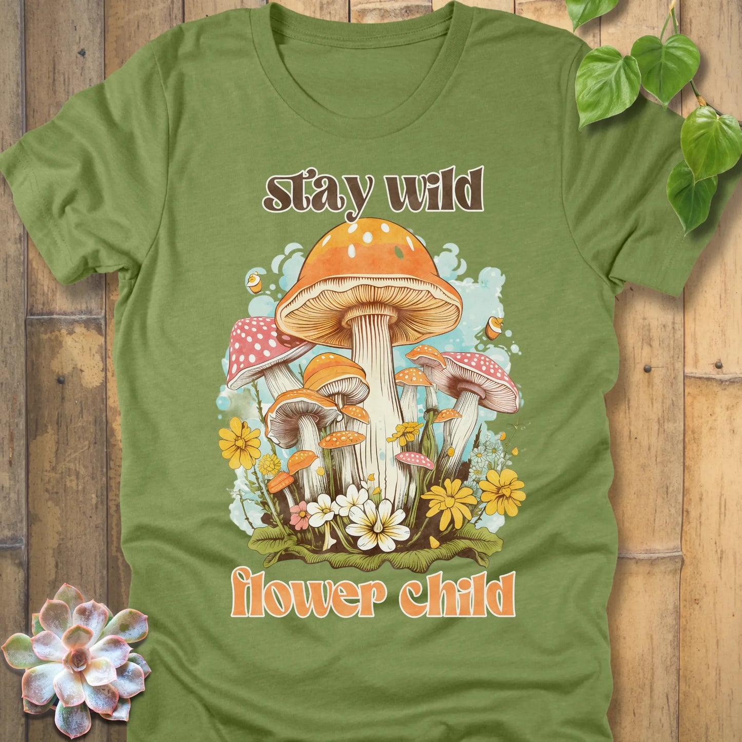 Heather Green t-shirt featuring the design Stay Wild Flower printed in bold letters, floral graphic tee.