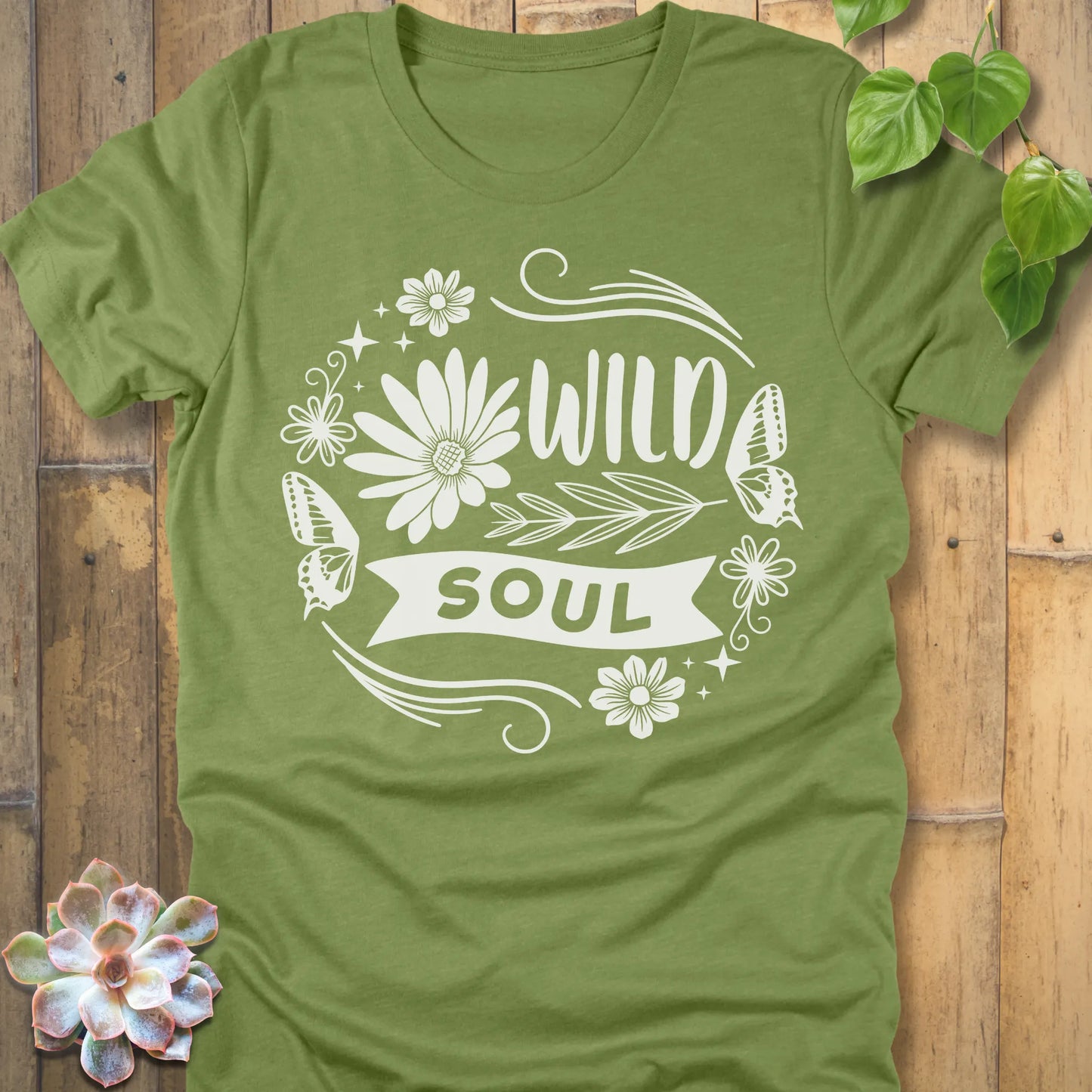 Heather Green t-shirt featuring the design Wild Soul printed in bold letters and flower, butterfly