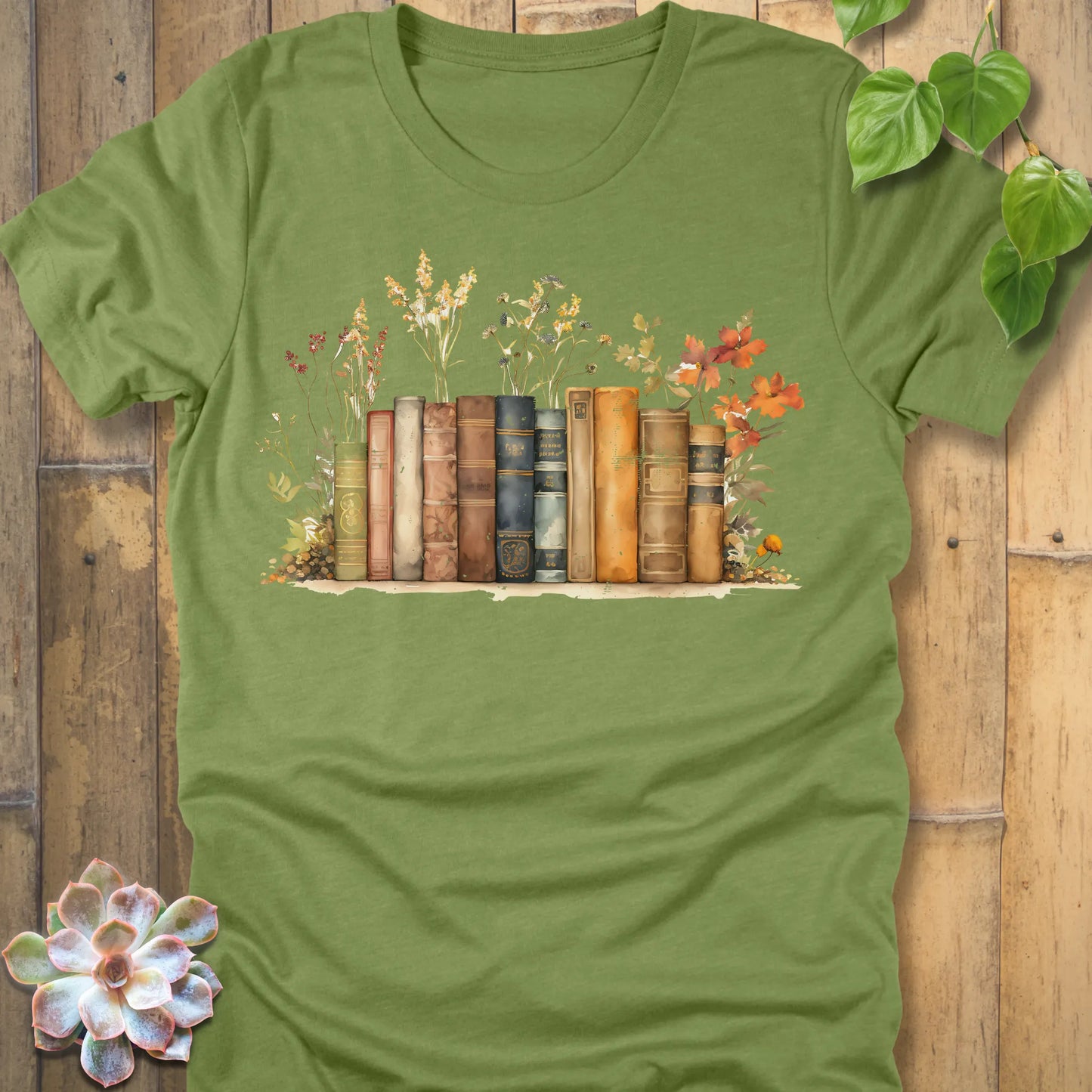 Heather Green t-shirt featuring the design Wildflower Library printed with books and plants, floral graphic tee for plant lovers.