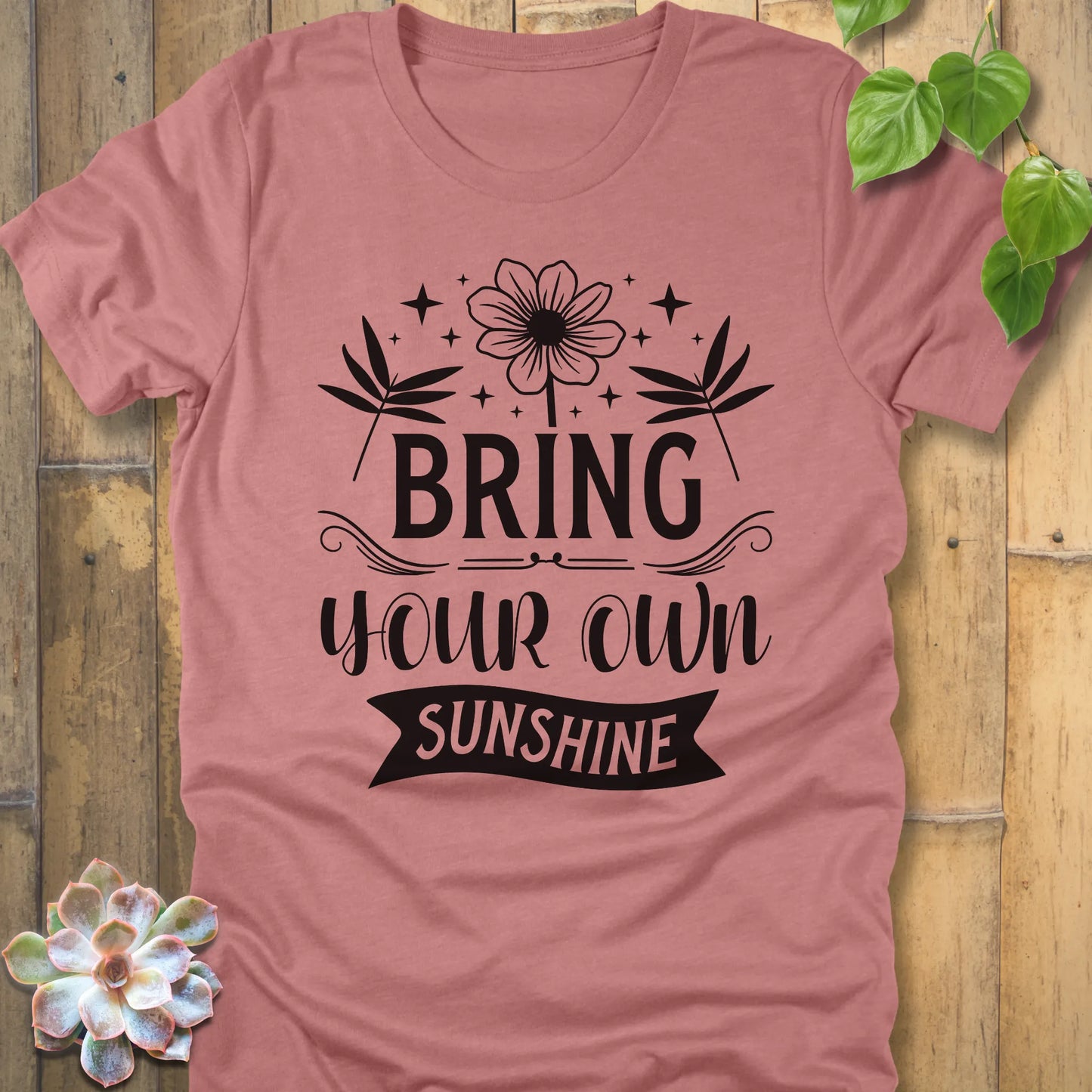 Heather Mauve t-shirt featuring the design "Bring Your Own Sunshine" printed in black lette and flower