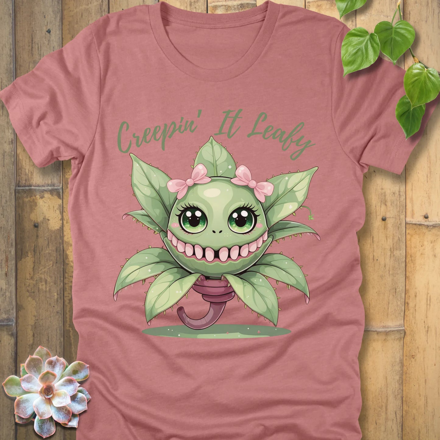 Heather Mauve t-shirt featuring the design Creepin' It Leafy printed in green letters and a happy plant