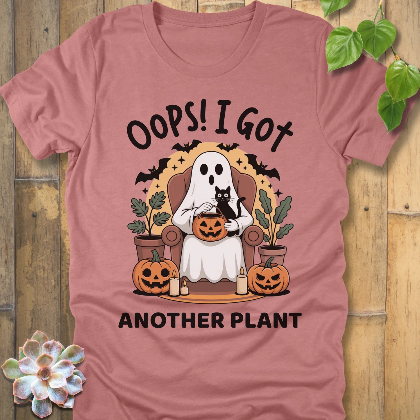 Heather Mauve t-shirt featuring the design "Oops! I Got Another Plant" printed in bold black letters, and a ghost, cat, plants, bats and pumpkin