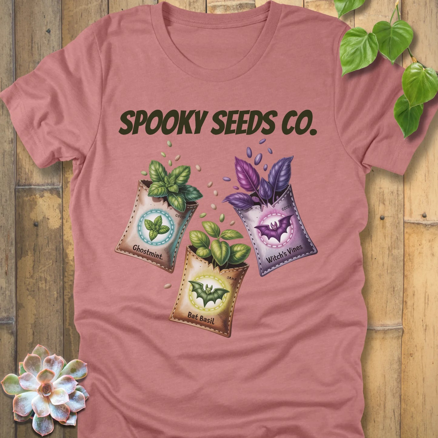 Heather Mauve t-shirt featuring the design Spooky Seeds Co. printed in bold letters  and a halloween design and plants