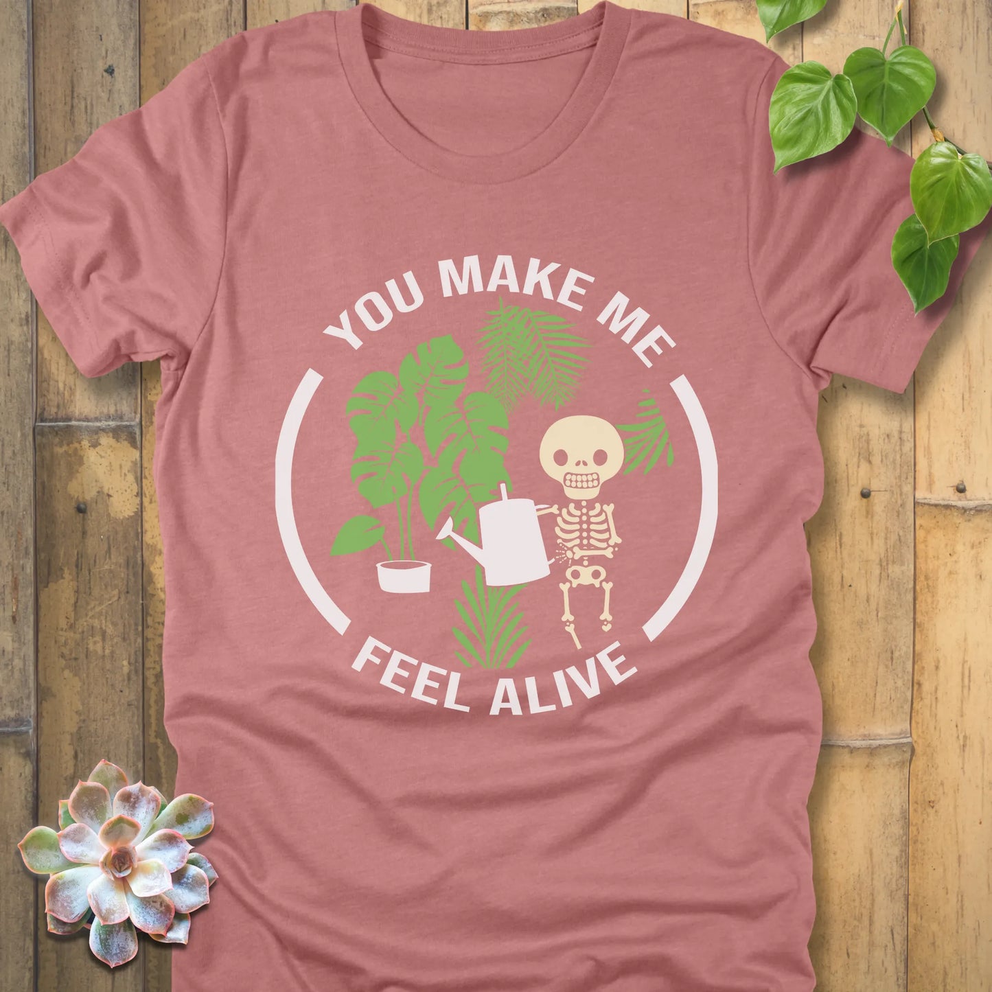 Heather Mauve t-shirt featuring the design You make me feel alive with plant and skeleton in bold white letters