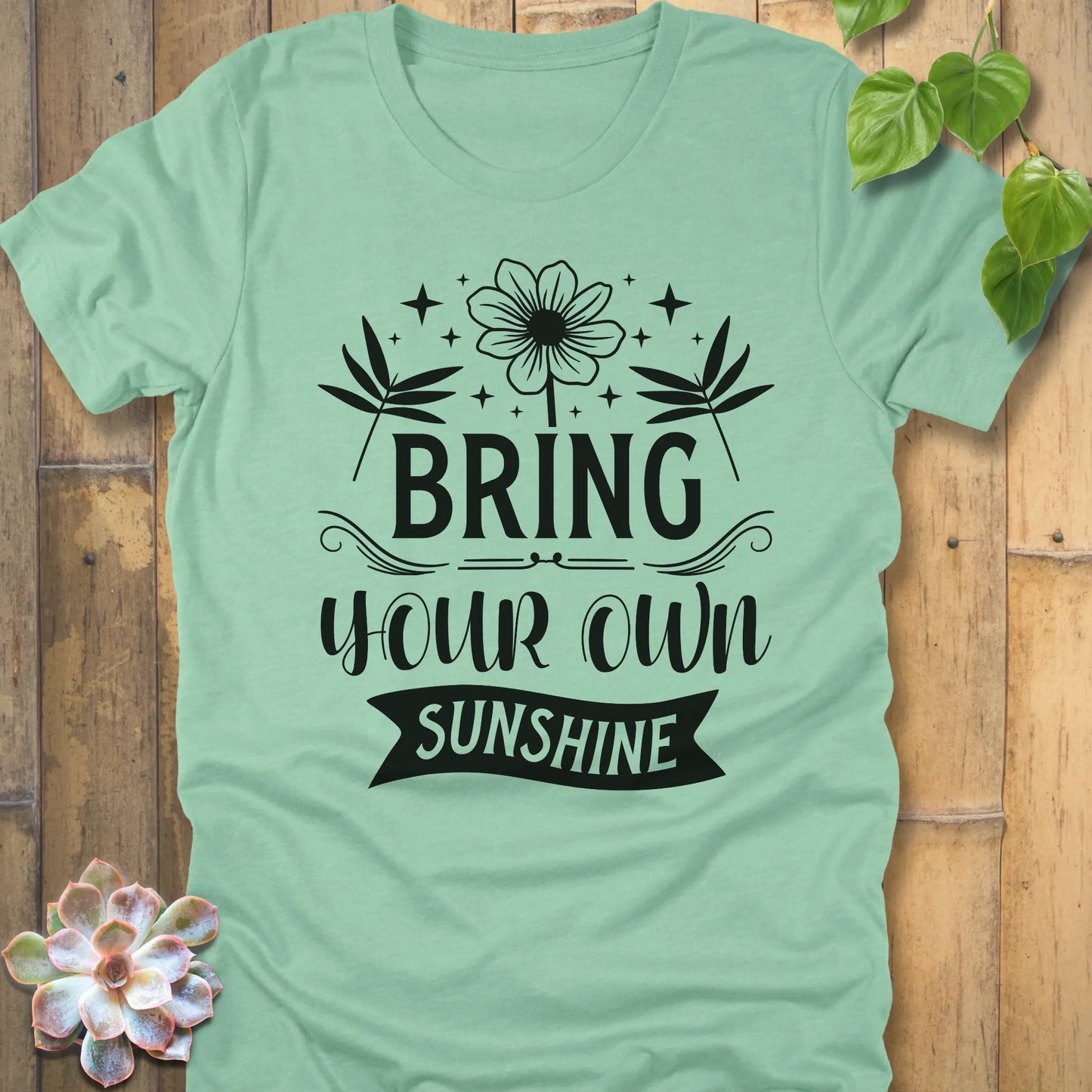 Heather Mint t-shirt featuring the design "Bring Your Own Sunshine" printed in black lette and flower
