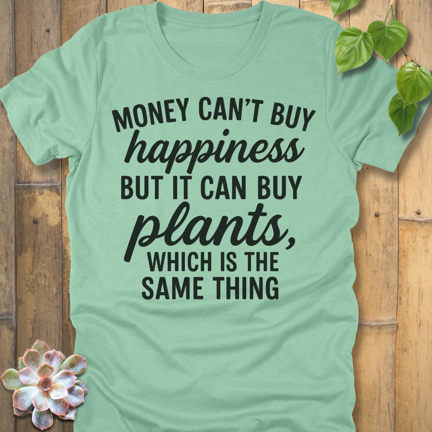 Heather Mint t-shirt featuring the design Money Can’t Buy Happiness printed in bold black letters, motivational quote shirt.