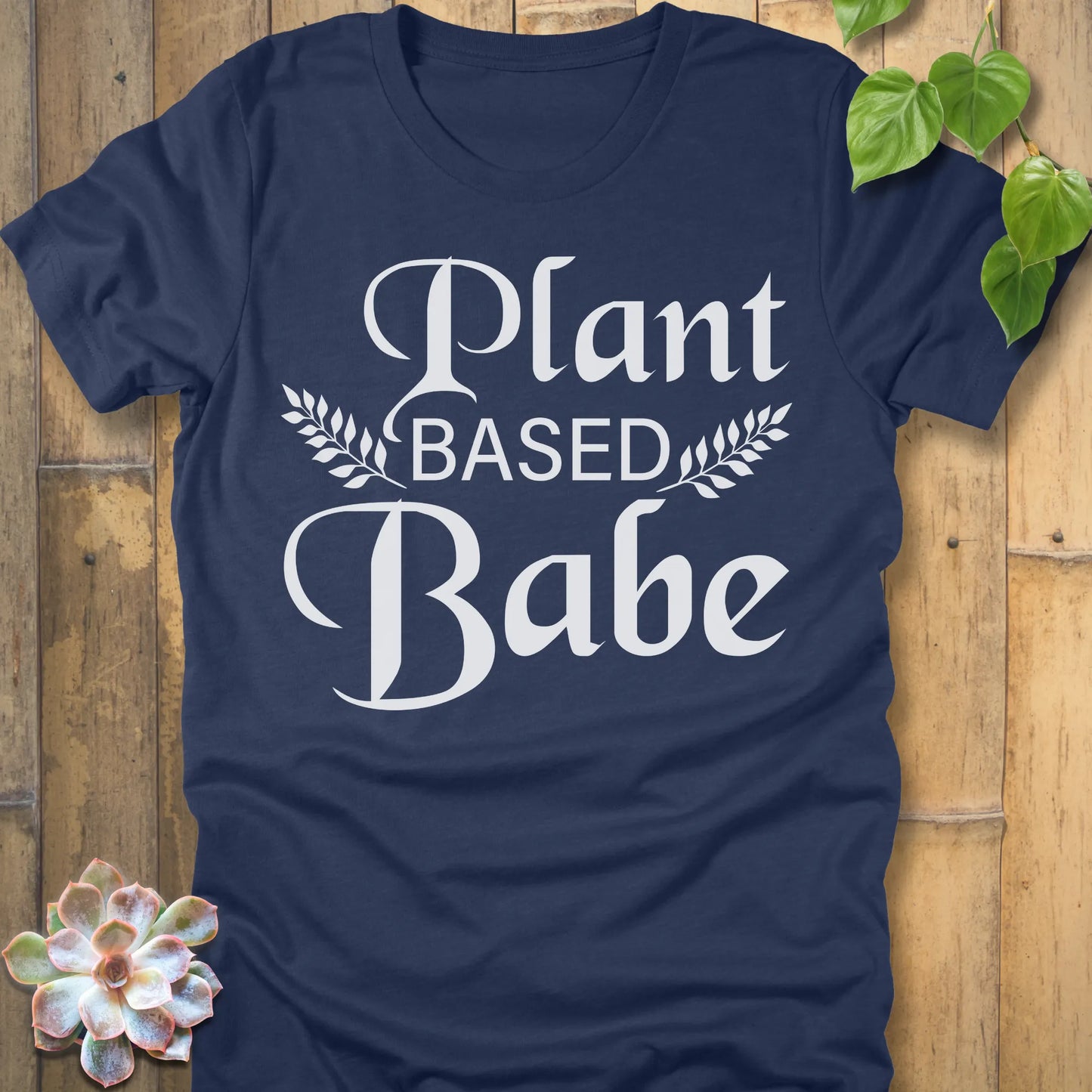Heather Navy t-shirt featuring the design Plant Based Babe printed in bold letters and a graphic leaves, vegan lifestyle shirt.