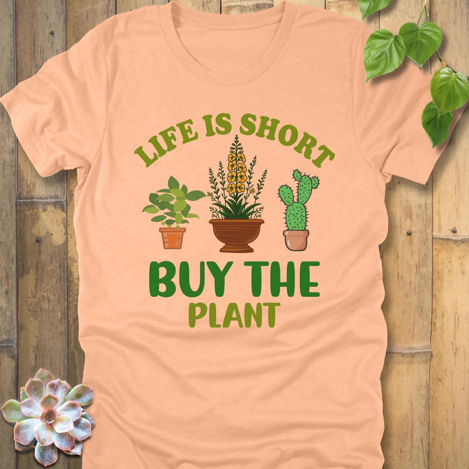 Heather Peace t-shirt featuring the design Life is short, buy the plant printed in green letter with plant illustration