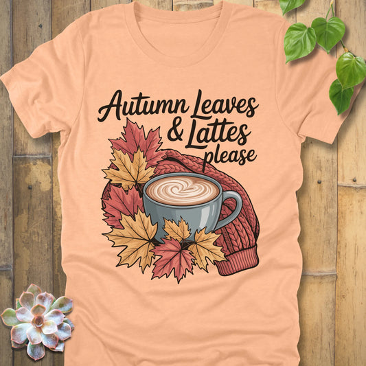 Heather Peach t-shirt featuring the design Autumn Leaves & Lattes printed in black letters with a mug of coffee and leaves