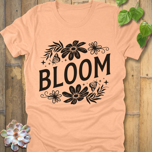 Heather Peach t-shirt featuring the design " Bloom " printed in bold black letters with flowers