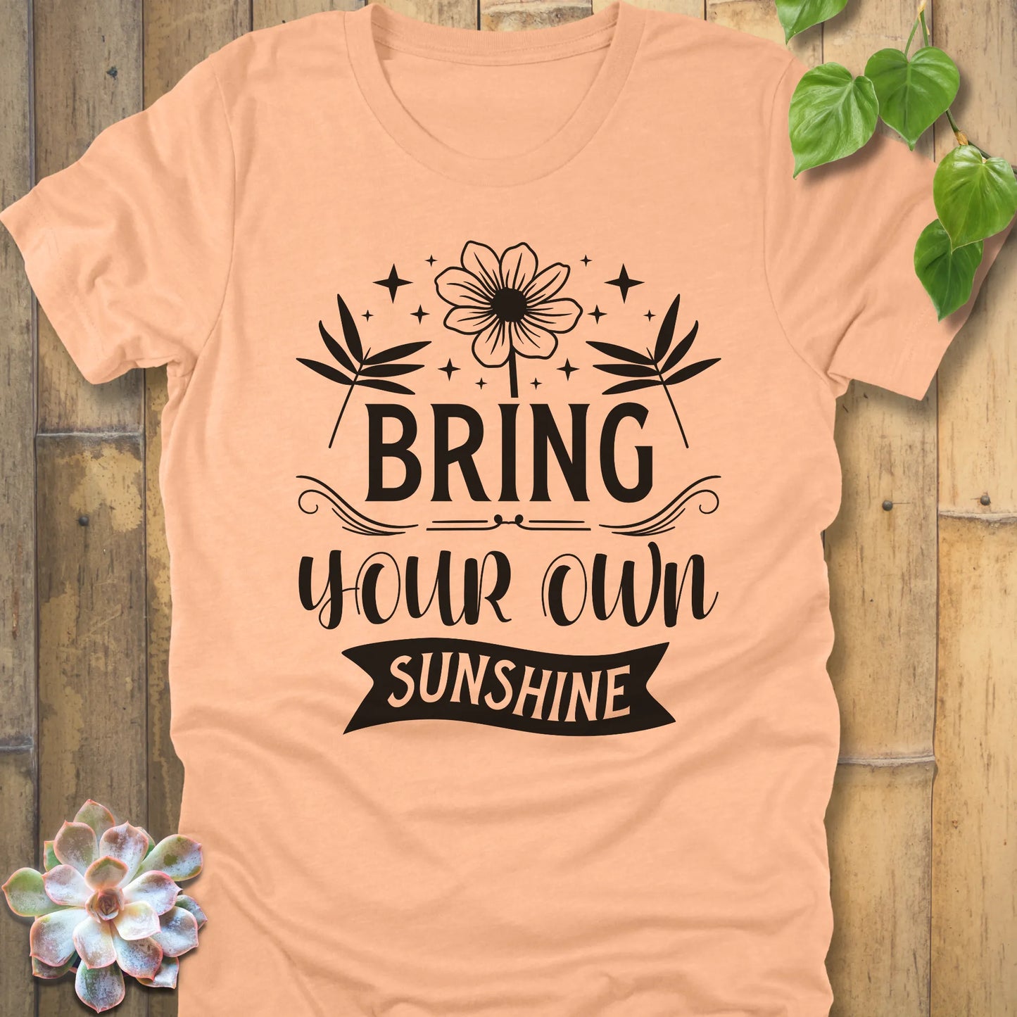 Heather Peach t-shirt featuring the design "Bring Your Own Sunshine" printed in black lette and flower