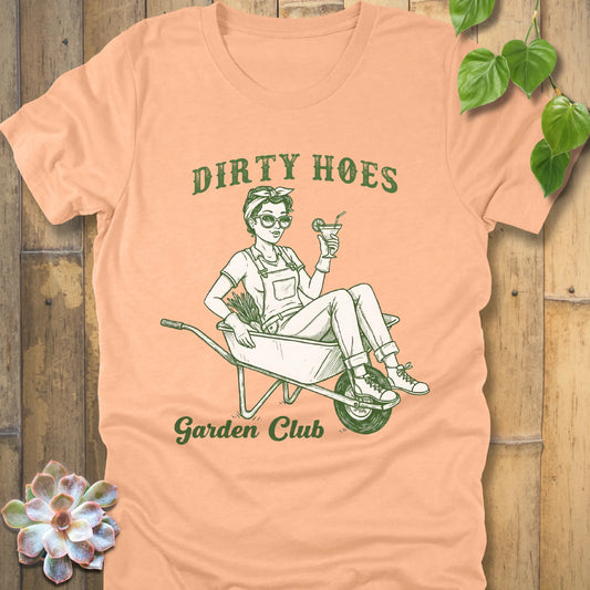 Heather Peach t-shirt featuring the design Dirty Hoes, Garden Club printed in green letters with a girl in the trolley, gardening graphic tee.