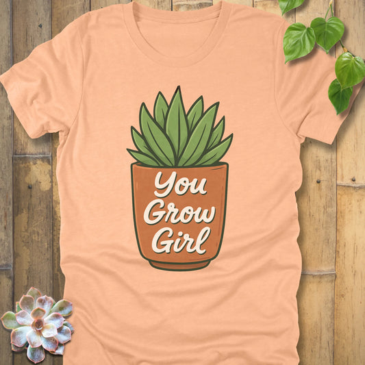 Heather Peach t-shirt featuring the design Grow Girl printed in bold letters and plant in the pot, casual plant lover shirt.