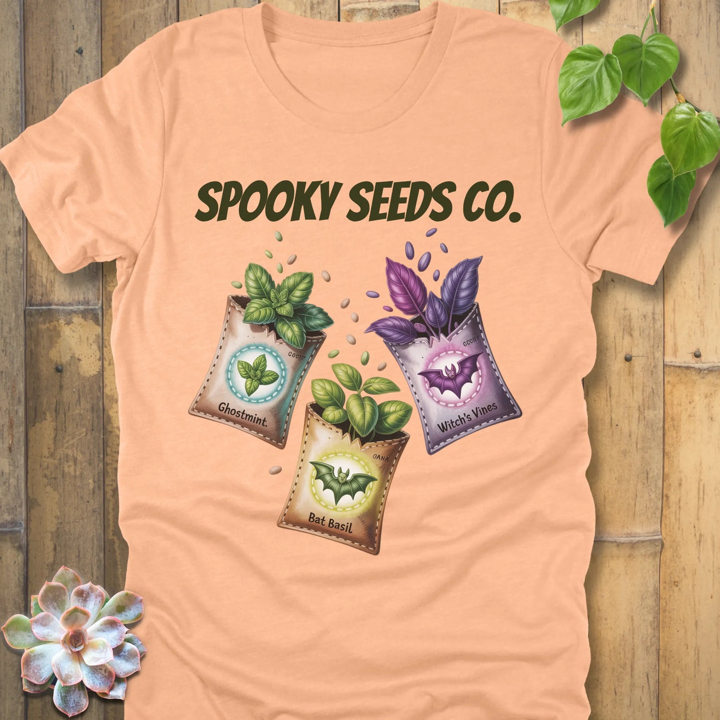Heather Peach t-shirt featuring the design Spooky Seeds Co. printed in bold letters  and a halloween design and plants