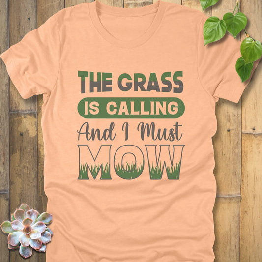 Heather Peach t-shirt featuring the design The Grass is Calling and I Must Mow in bold letters and with grass