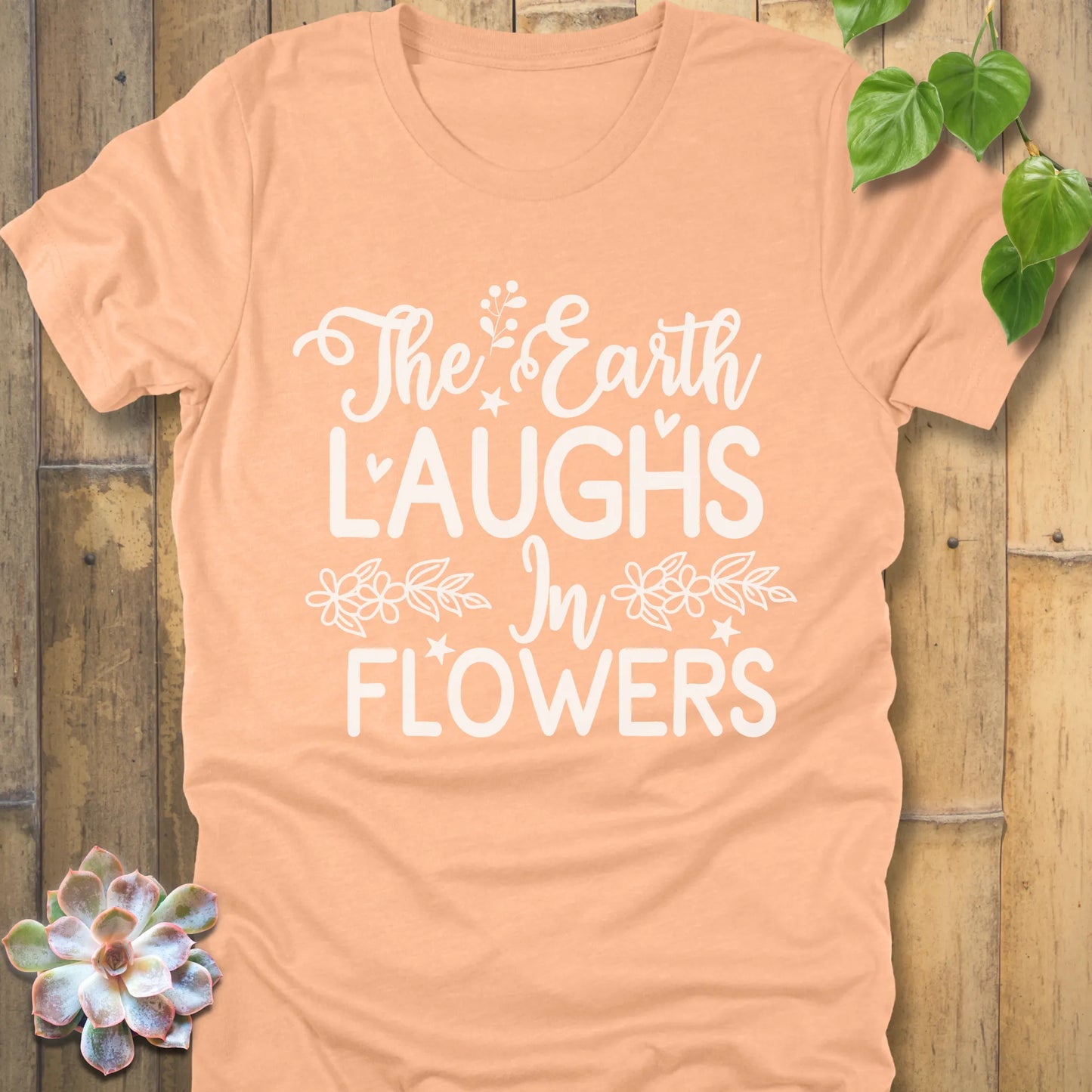 Heather Peach t-shirt featuring the design The earth laughs in flowers printed in bold white letters