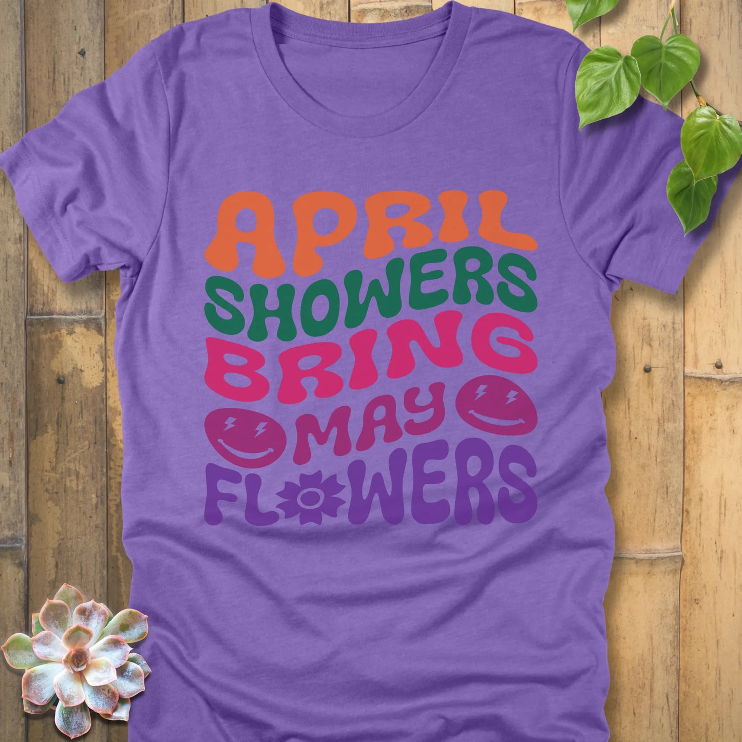 Heather Team Purple t-shirt featuring the design April Shower printed in bold colorful letters, casual gardening shirt.