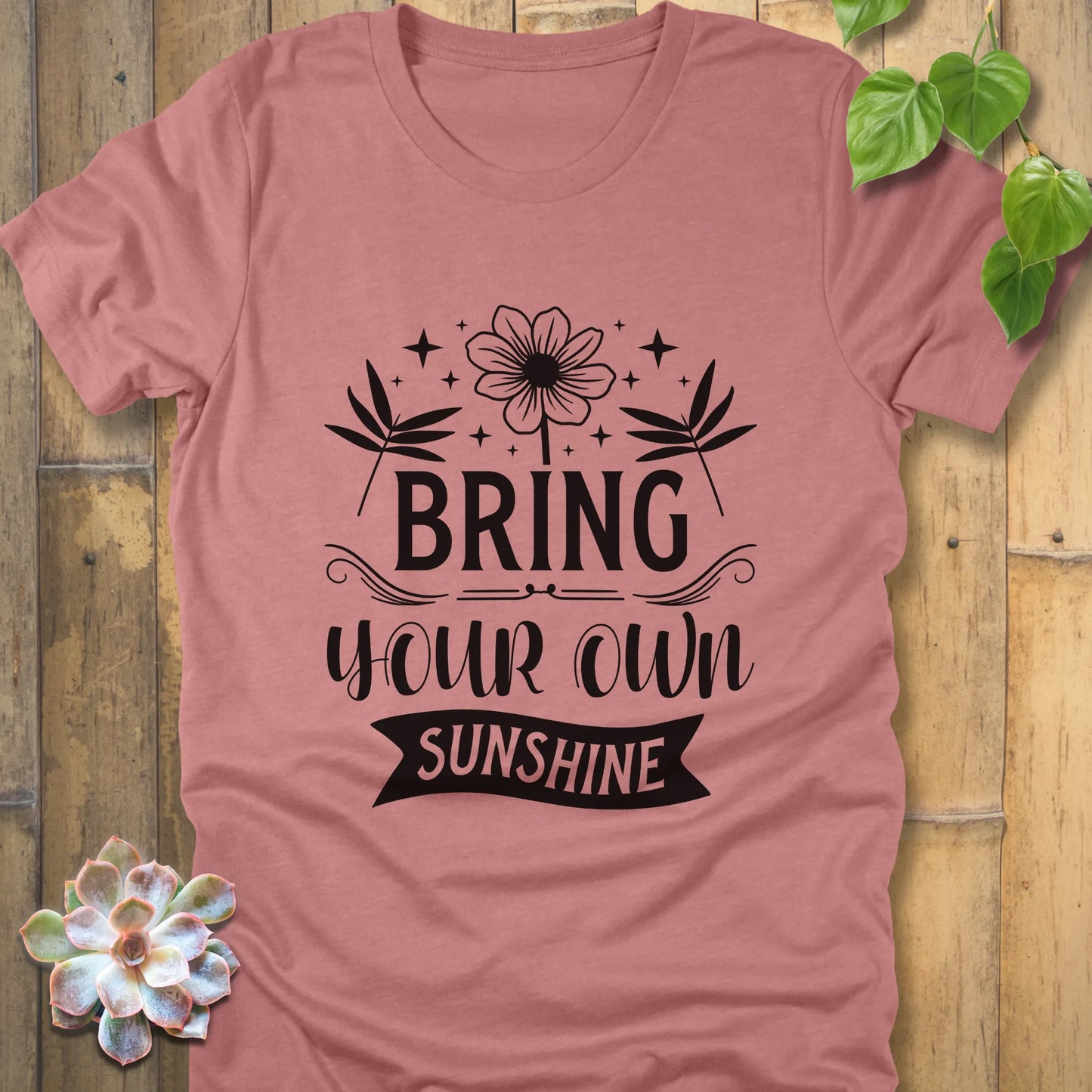 Heather mauve t-shirt featuring the design "Bring Your Own Sunshine" printed in black letter and flower