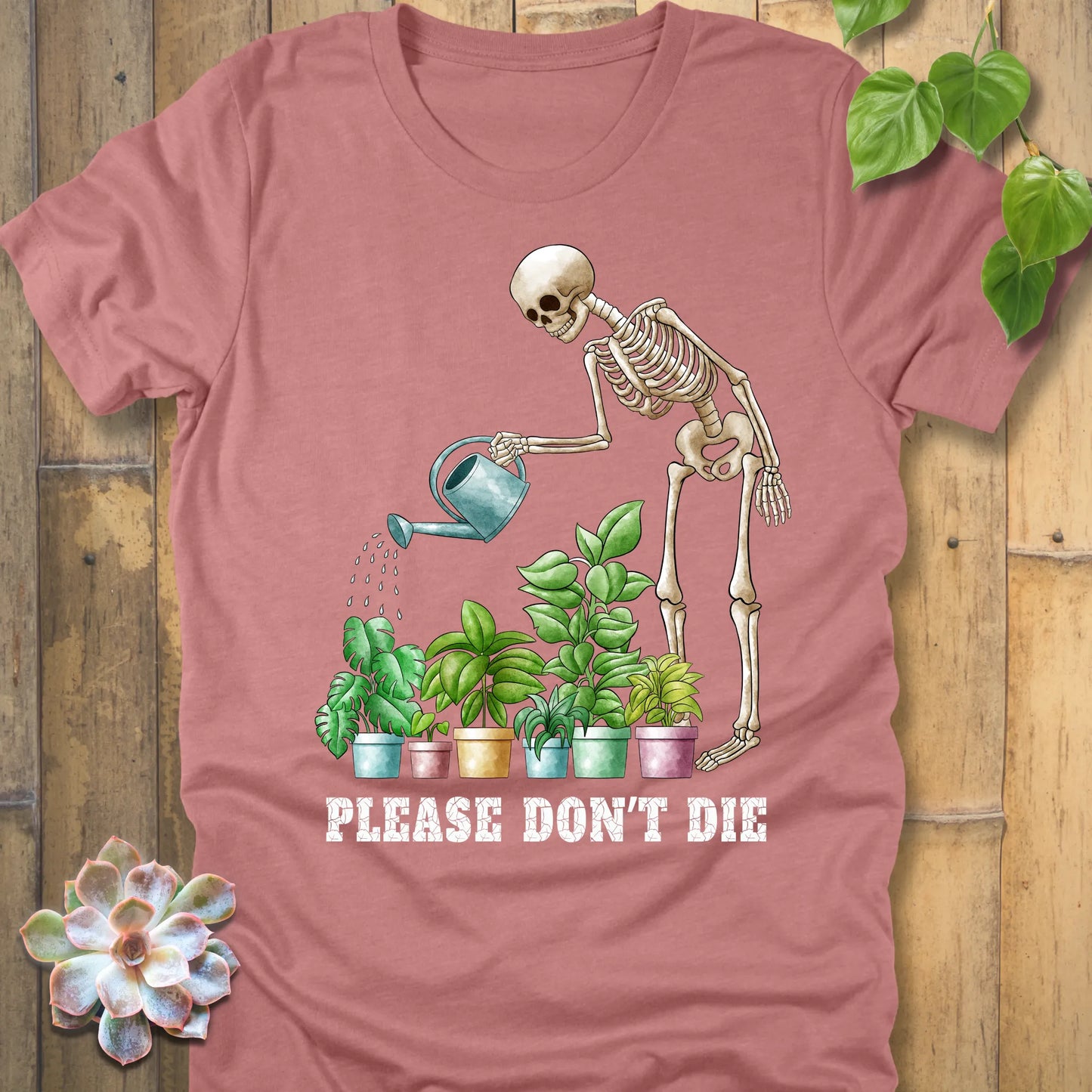 Heather mauve t-shirt featuring the design Please Don’t Die with skeleton watering plants print