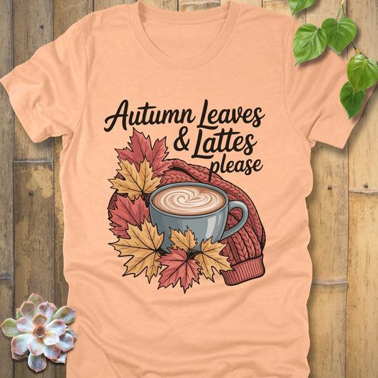 Heather peach t-shirt featuring the design Autumn Leaves & Lattes printed in black letters with a mug of coffee and leaves