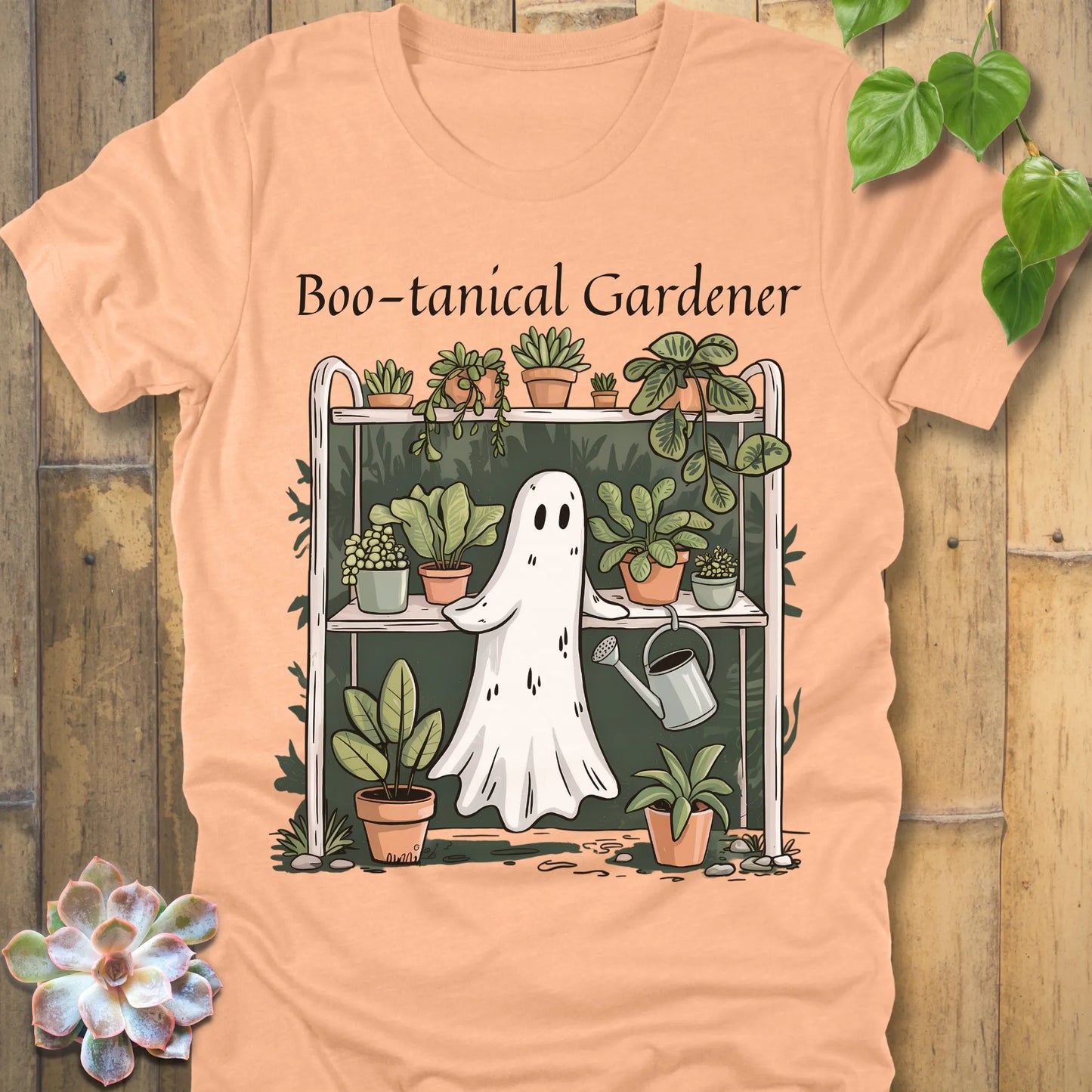 Heather peach t-shirt featuring the design Boo – tanical Gardener printed in black letters and a ghost in garden