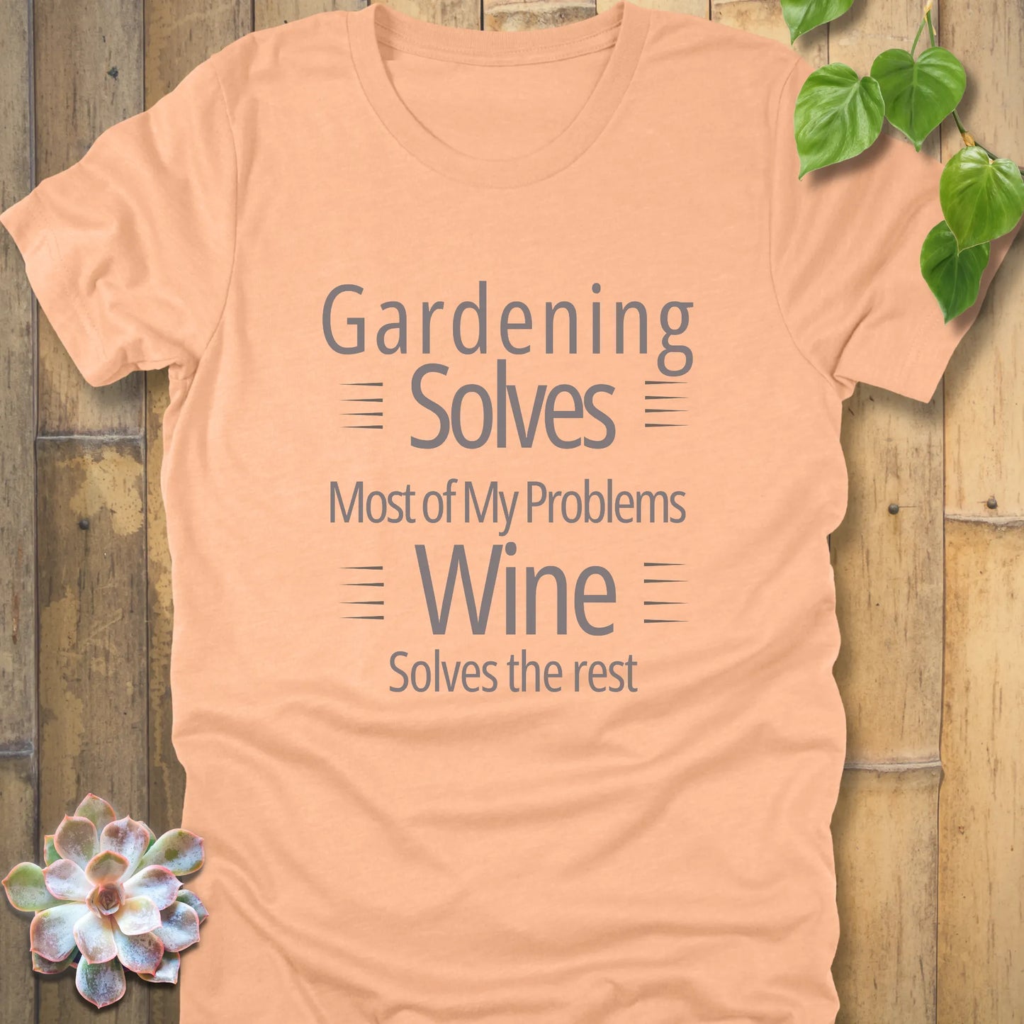 Heather peach t-shirt featuring the design Gardening solves most of my problem, wine solves the rest printed in bold black letters.
