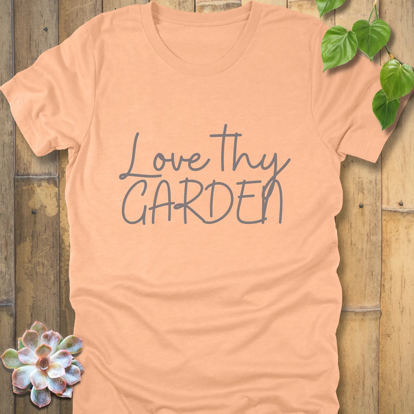 Heather peach t-shirt featuring the design Love Thy Garden printed in grey letters