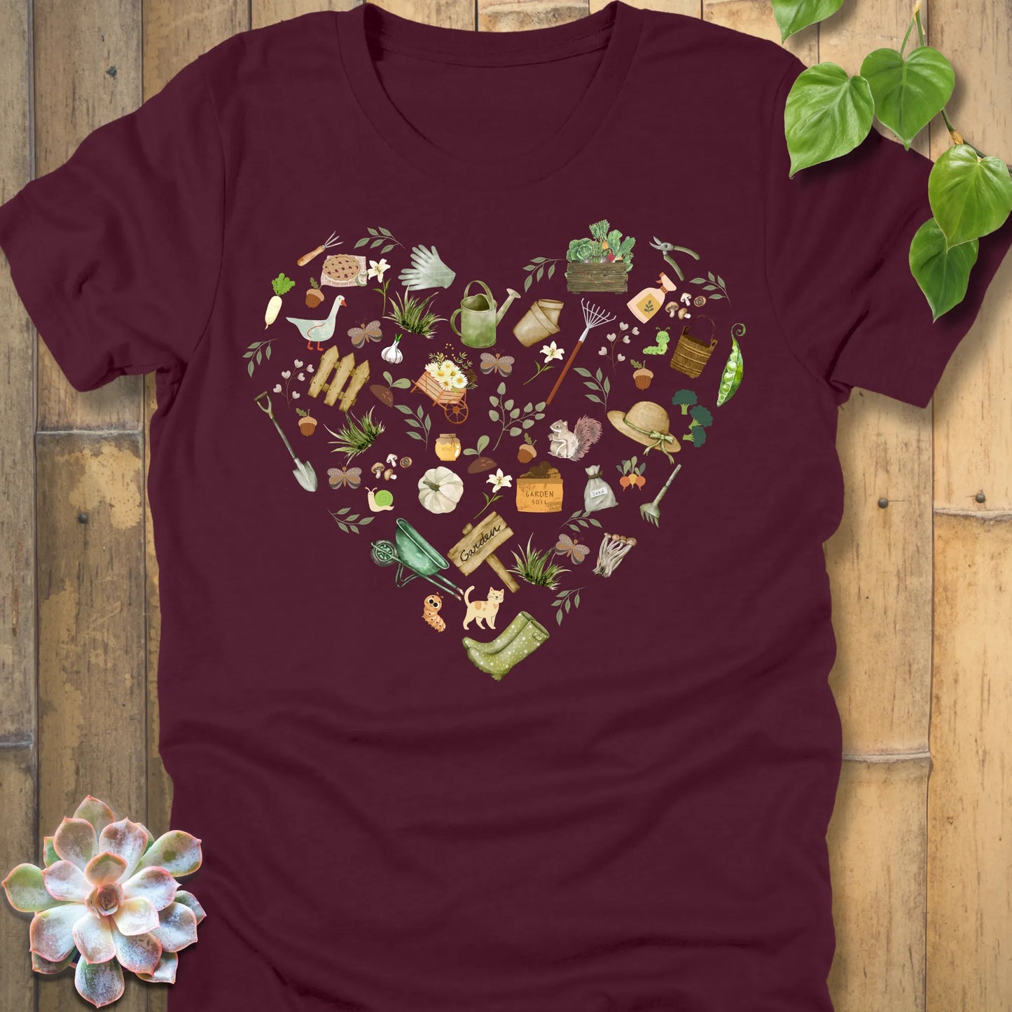 Maroon t-shirt featuring the design Gardening Loveheart printed in heart shape with tools, plant lover shirt.