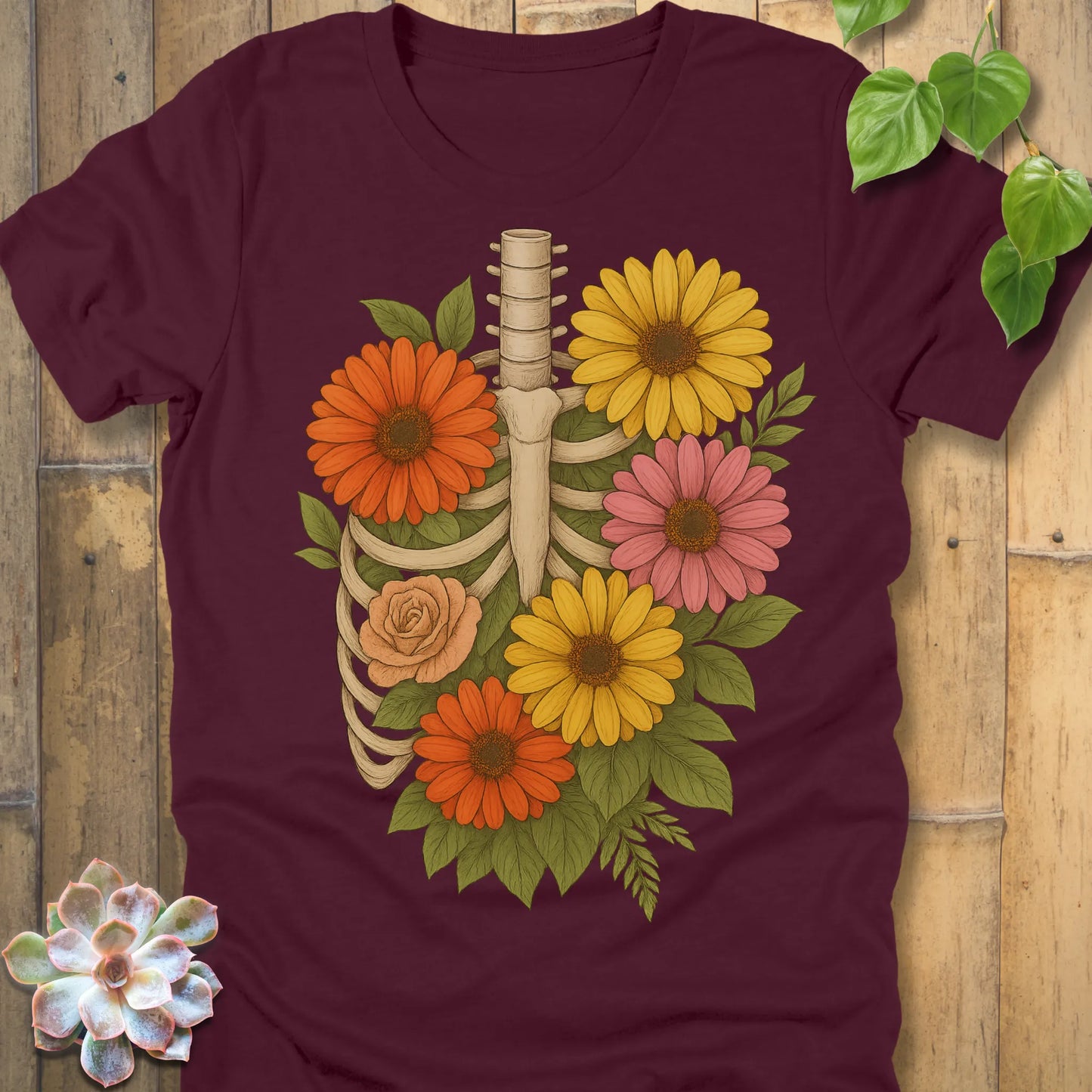 Maroon t-shirt featuring the design Gerbera Bones halloween floral skeleton graphic tee.
