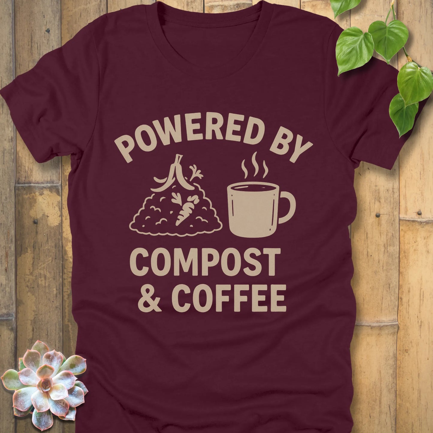 Maroon t-shirt featuring the design Powered By Compost & Coffee printed in bold letters with mug of coffee