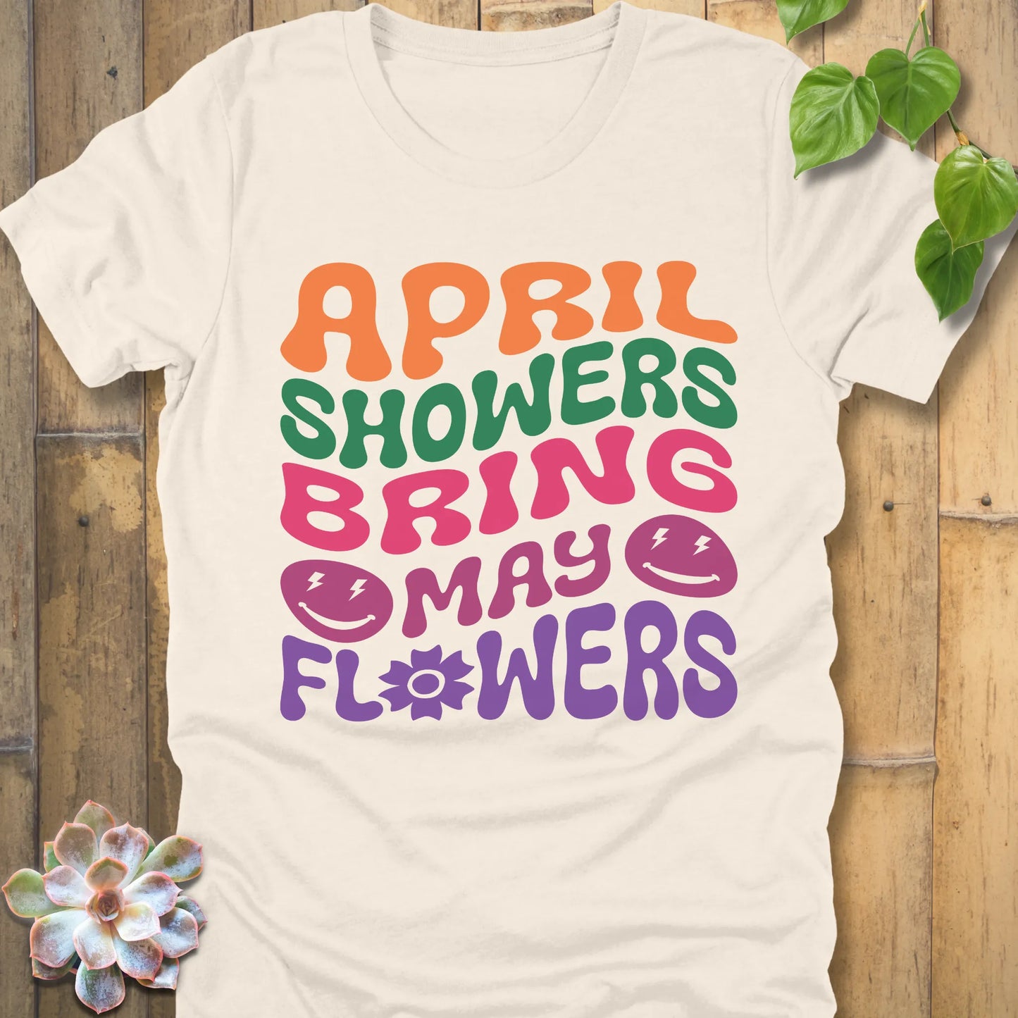 Natural t-shirt featuring the design April Shower printed in bold colorful letters, casual gardening shirt.