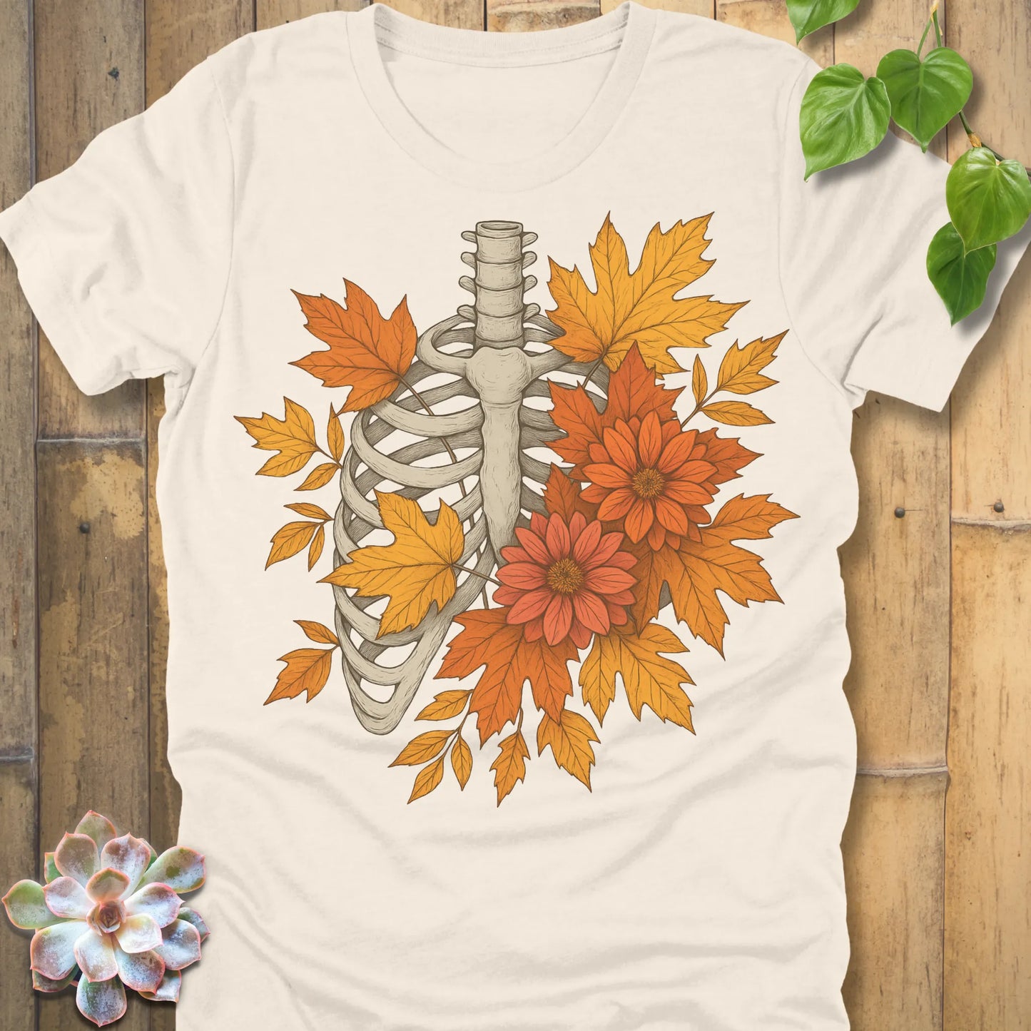 Natural t-shirt featuring the design Autumn Bones printed Halloween skeleton shirt with flowers and leaves.