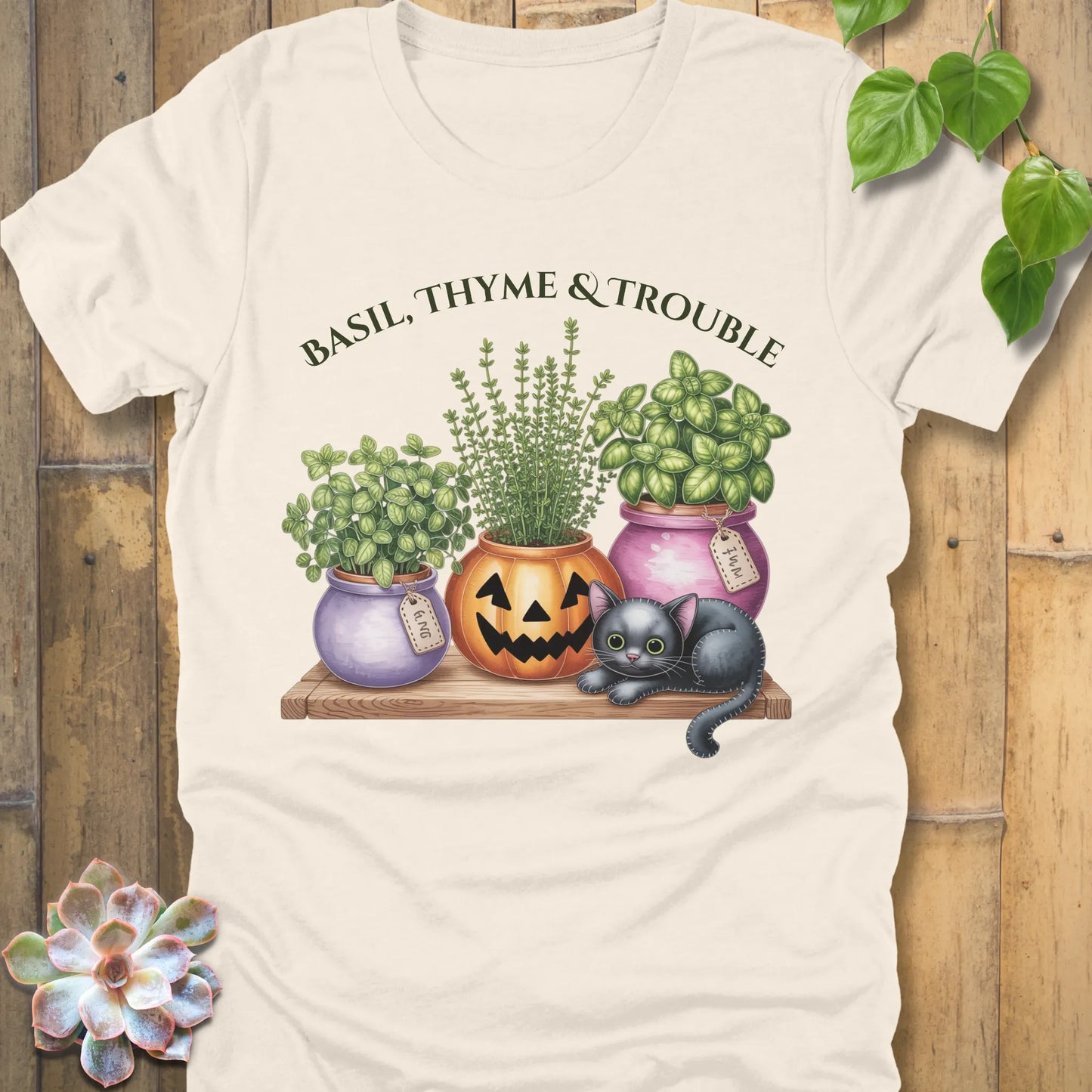 Natural t-shirt featuring the design "Basil, Thyme & Trouble" printed in bold green letters and a plants, cats 