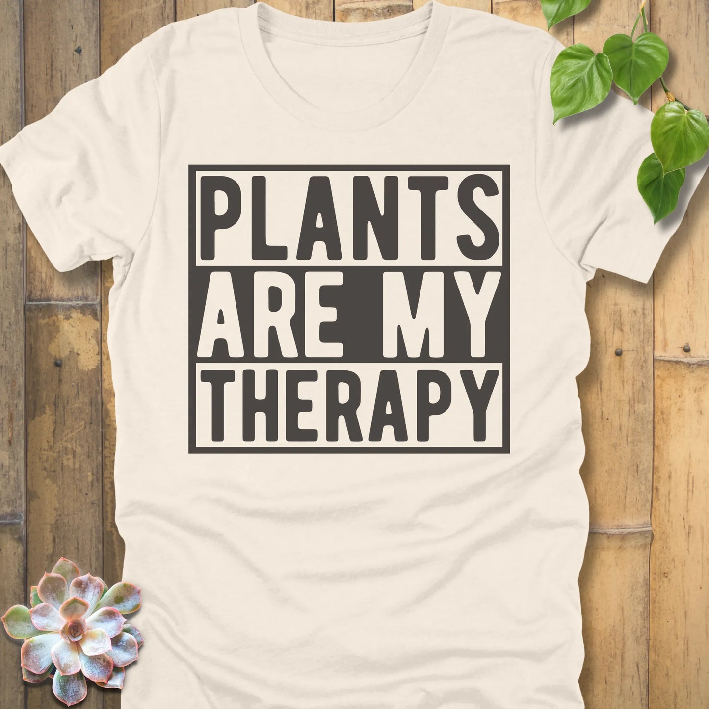 Natural t-shirt featuring the design Plants Are My Therapy printed in bold letters, plant lover shirt.