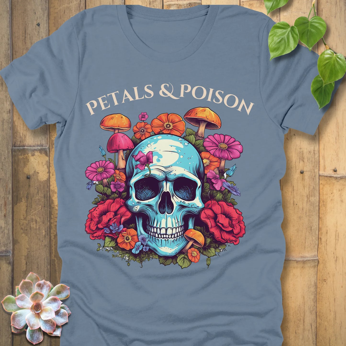 Steel Blue t-shirt featuring the design Petals & Poison printed in bold letters and a flowers, mushroom and skull