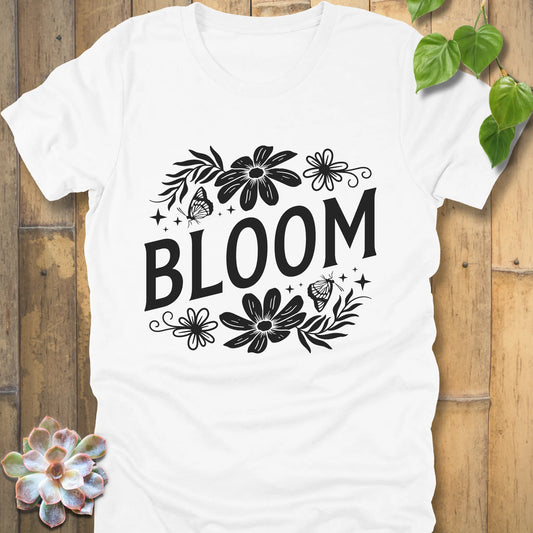 White t-shirt featuring the design " Bloom " printed in bold black letters with flowers
