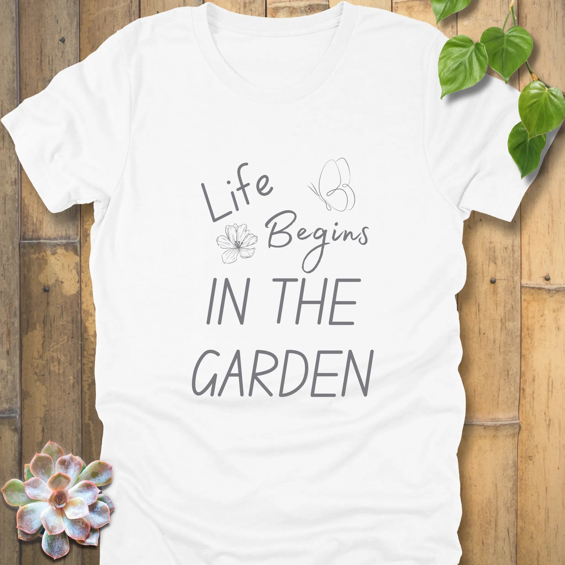 White t-shirt featuring the design Life begin's in the garden, gardening graphic tee for plant lovers.
